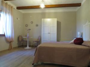 a bedroom with a bed and a table with chairs at Casale Santa Margherita in Bucine