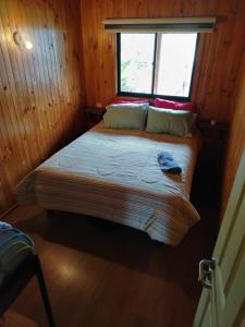 a bed in a room with a window at Hospedaje Sandra in Llanquihue +3 photos