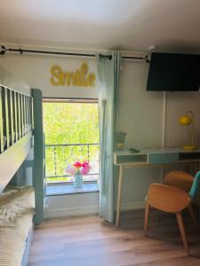a bedroom with a window with a bed and a desk at Camping Hôtel Maui in Tournon-sur-Rhône