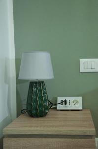 a lamp on a table next to a alarm clock at La Casetta di Gio' con Parcheggio in Lerici
