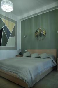 a bedroom with a large bed and a clock on the wall at La Casetta di Gio' con Parcheggio in Lerici