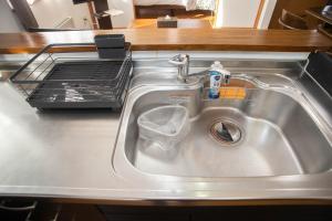 a kitchen sink with a dish drying rack behind it at Guest House Nishimiyanosawa in Teine +79 photos