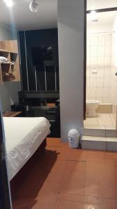 a bedroom with a bed and a bathroom with a tub at HotelesR20 in Lima