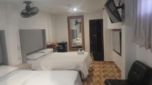 a hotel room with two beds and a mirror at HotelesR20 in Lima