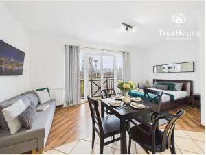a living room with a couch and a table with chairs at Apartament Pasaż 3 in Giżycko