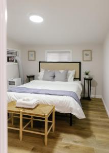 a white bedroom with a large bed and a table at Seabiscuit Loft - Studio in Downtown Lexington in Lexington