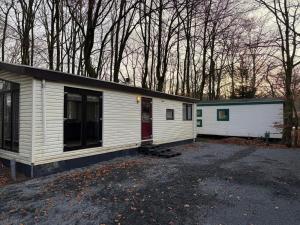 a white house with a red door in a parking lot at First houses 82 in Rijen