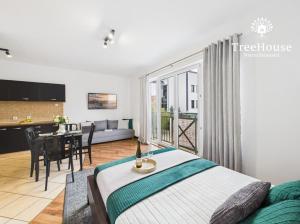 a bedroom with a bed and a table and a kitchen at Apartament Pasaż 3 in Giżycko