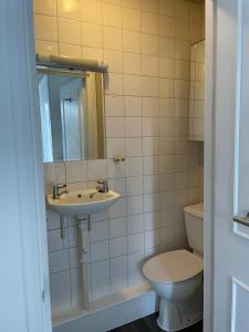 a bathroom with a sink and a toilet at Self Contained Studio Flat in London