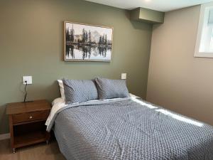 a bedroom with a bed and a picture on the wall at The Basement Suite on Paradise Hill in Prince George
