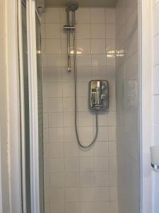 a bathroom with a shower with a glass door at Self Contained Studio Flat in London
