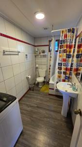 a small bathroom with a toilet and a sink at Cabañas y hostal Aurora in Castro +30 photos