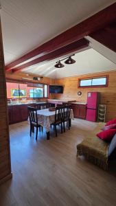 a dining room with a table and chairs in a room at Cabañas y hostal Aurora in Castro
