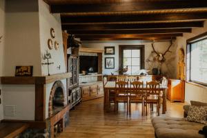 a kitchen and dining room with a table and a fireplace at Viesu nams Smēdes in Limbaži