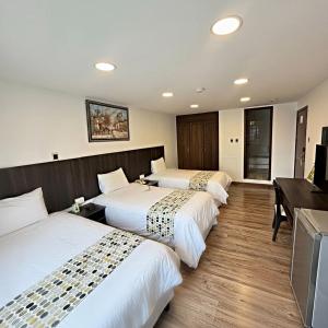 ein Hotelzimmer mit drei Betten und einem Schreibtisch in der Unterkunft Hotel Republica in Quito + 128 Fotos