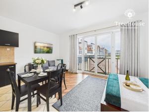 a dining room and living room with a table and a balcony at Apartament Pasaż 3 in Giżycko +11 photos