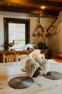a table with a vase of flowers on top of it at Viesu nams Smēdes in Limbaži
