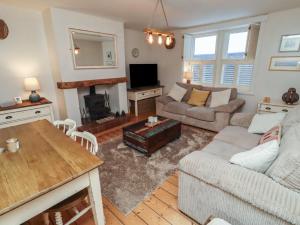 a living room with a couch and a table at Corner Cottage in Seahouses