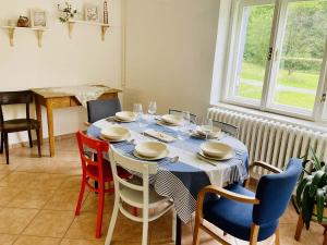 a dining room with a table and chairs and a window at Chalupa U Revíru in Chvalčov