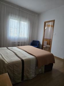 a bedroom with a bed and a mirror and a chair at Hotel Espada a 174 kilómetros de Santiago de Compostela in A Rúa