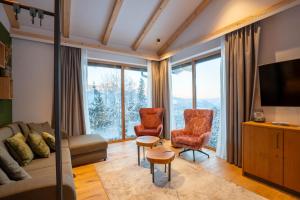 a living room with a couch and two chairs at Höflehner Premium Eco Lodge in Haus im Ennstal