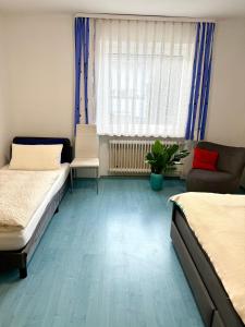 a room with two beds and a couch and a chair at Haus Elisabeth in Nagold