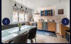 a kitchen with a table and chairs and blue cabinets at Haus Schwarzwald Marie in Mahlberg