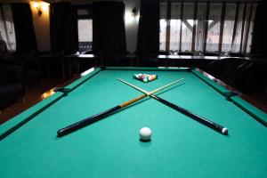 a pool table with three cue sticks and a ball at Hanul Simonului in Bran