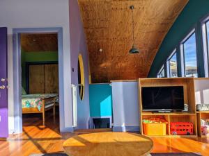 a living room with a television and a surfboard at Copacabana Fab & Funky in Copacabana