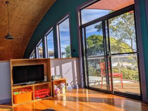 a living room with a tv and large sliding glass doors at Copacabana Fab & Funky in Copacabana +33 photos