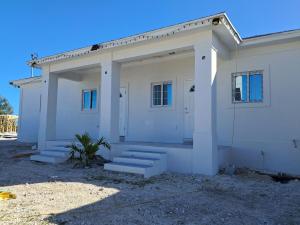 a white house with stairs in front of it at Marie view Rentals in Abaco