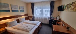 a hotel room with two beds and a desk at 2x Einzelbetten - Gästezimmer - 11min von Gießen Zentrum 8,4km in Fernwald in Steinbach