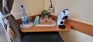 a table with a coffee maker and a bottle on it at 2x Einzelbetten - Gästezimmer - 11min von Gießen Zentrum 8,4km in Fernwald in Steinbach +17 photos