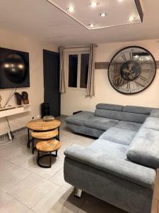 a living room with a couch and a clock on the wall at Maison à la campagne in Mecquignies