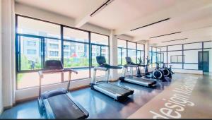 a gym with several treadmills and a row of windows at Two-Bedroom Apartment Near JKIA & SGR Free Parking & Wi-Fi By Irene in Nairobi