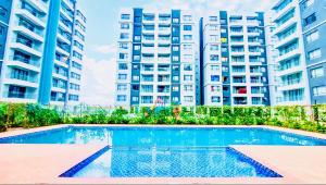 a swimming pool in front of some tall buildings at Two-Bedroom Apartment Near JKIA & SGR Free Parking & Wi-Fi By Irene in Nairobi