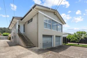 a white house with a garage at Bliss on Third in Whangarei