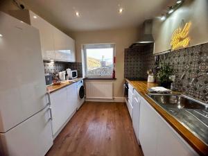 a kitchen with a white refrigerator and a sink at Kearton Guest House in Thwaite