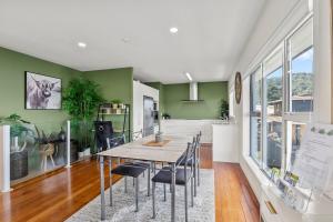 a dining room with green walls and a table and chairs at Bliss on Third in Whangarei