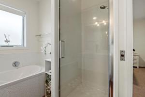 a white bathroom with a shower and a sink at Bliss on Third in Whangarei +11 photos