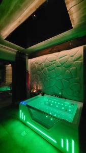 a pool table in a room with green lights at Cudodomek SPA Loft koło Ełku in Ełk
