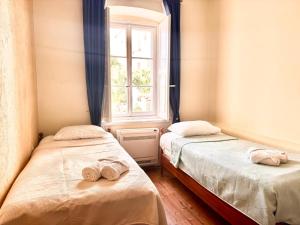 two beds in a room with a window at Miramare Seaside Aparts in Kotor
