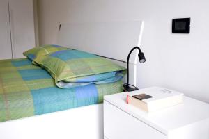 a bedroom with a bed with a lamp and a book at Armanni's House in Orio al Serio