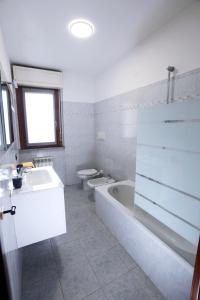 a bathroom with two toilets and a tub and a sink at Armanni's House in Orio al Serio +17 photos