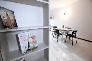 a dining room with a table and chairs and a book shelf at Armanni's House in Orio al Serio