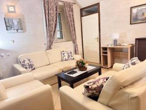 a living room with white couches and a table at Miramare Seaside Aparts in Kotor