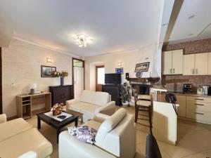 a living room with white furniture and a kitchen at Miramare Seaside Aparts in Kotor