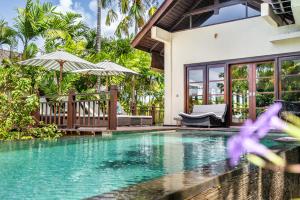 a villa with a swimming pool and a house at Boutique hotel villa Cantik and karma beach club in Uluwatu