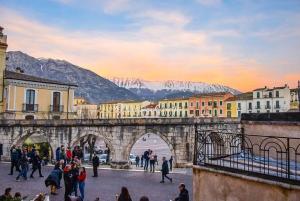 a group of people walking over a bridge with mountains at Corso Ovidio - Casa vacanze in Sulmona