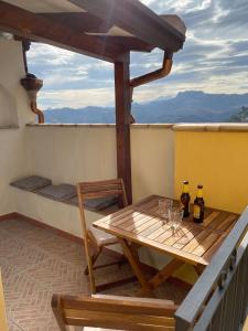 a table and chairs on a balcony with wine bottles at Casa zia Vincenzina in Casalvecchio Siculo